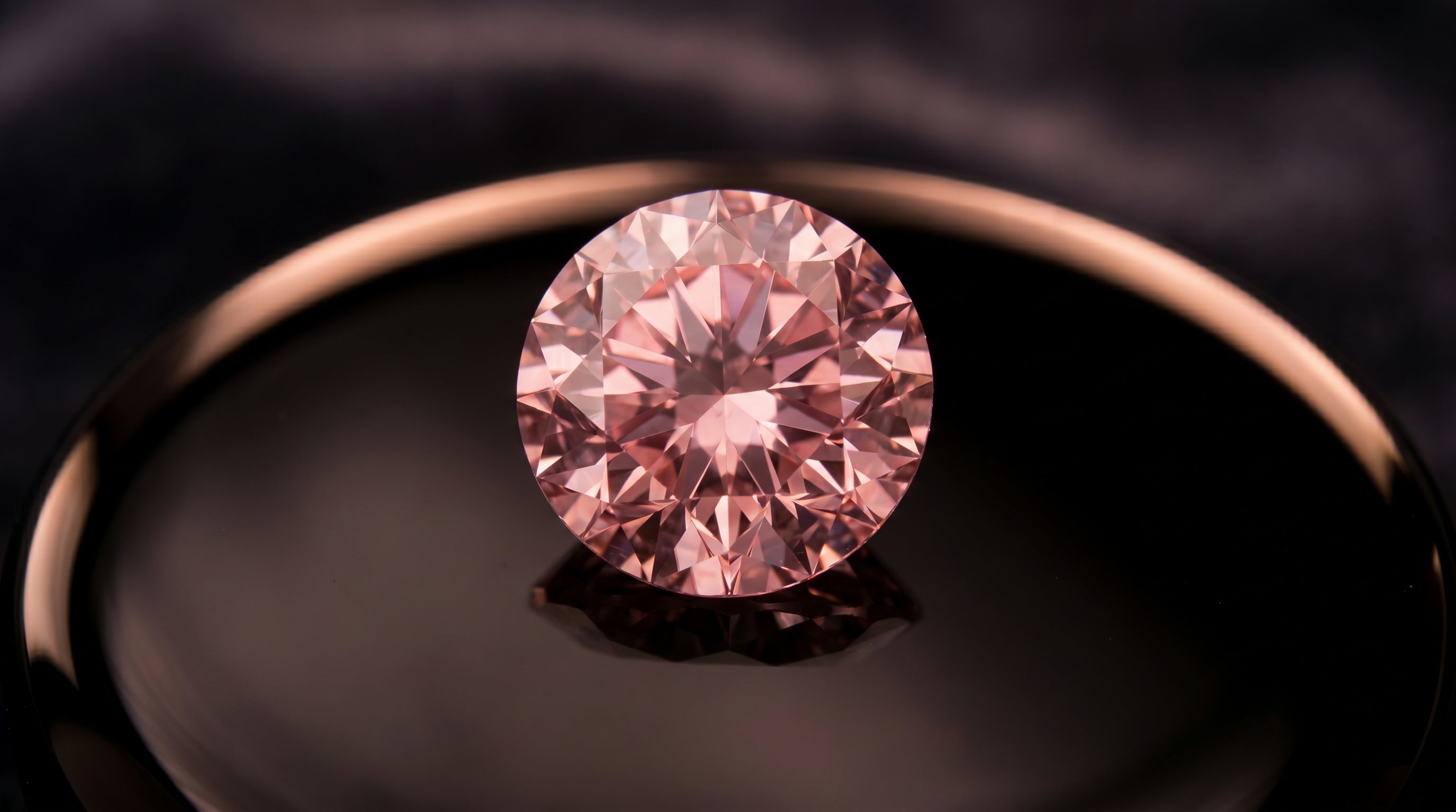 GIA-certified natural fancy vivid pink diamond on polished black onyx — investment-grade Argyle pink diamond