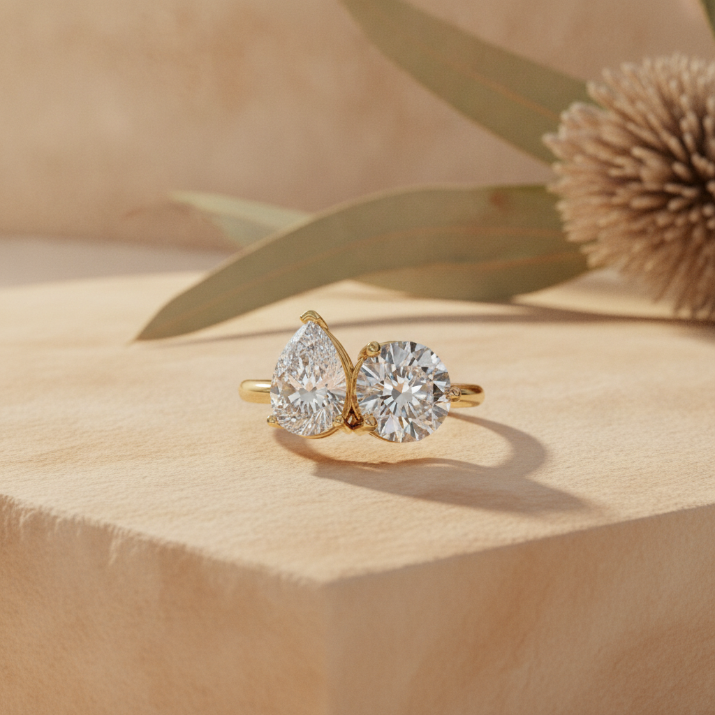 Toi et moi pear and round two-stone diamond ring on warm sandstone with native banksia — handcrafted in the Byron Bay Hinterland by Lucano