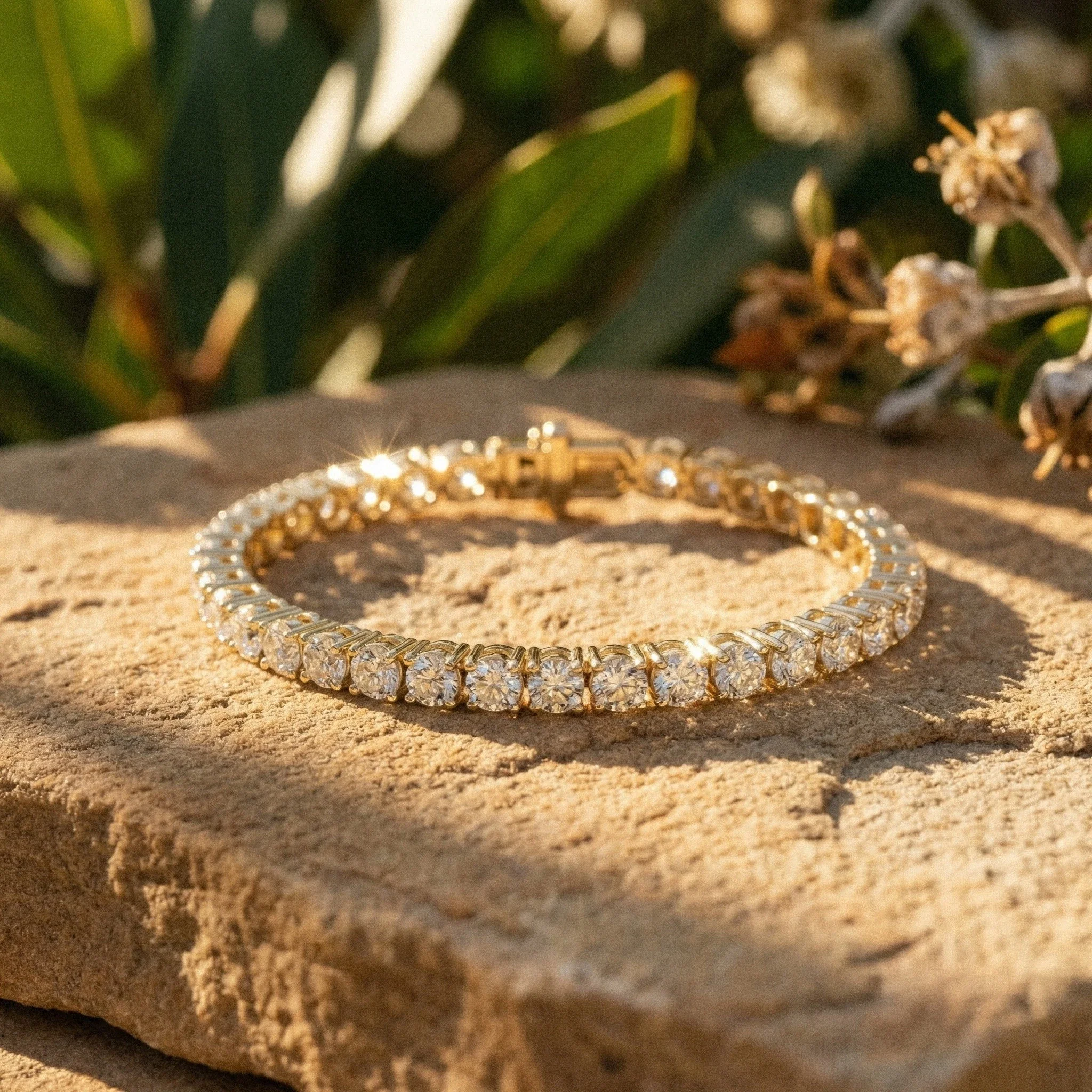 Ethical gold diamond tennis bracelet catching natural light on textured stone — Lucano