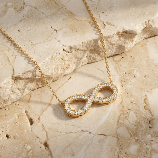 Diamond infinity necklace worn at the collarbone
