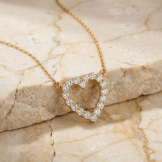Diamond heart necklace in gold worn at the collarbone