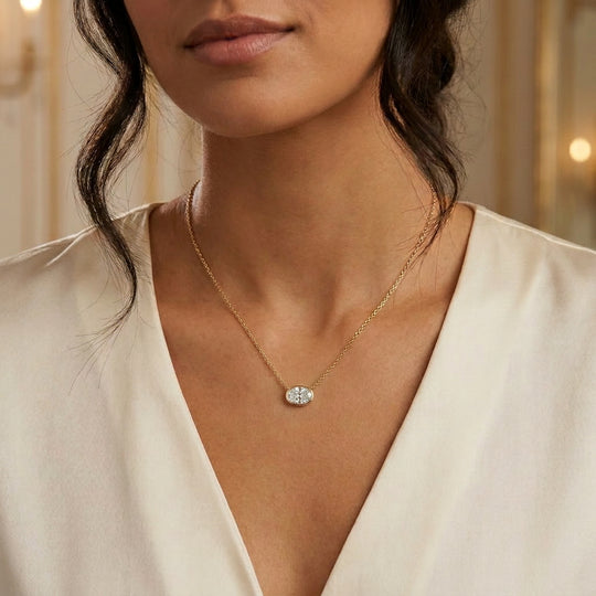 Ovalia oval diamond bezel pendant in gold worn at the collarbone