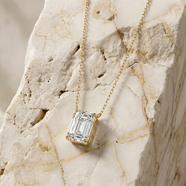 Chiara emerald-cut diamond solitaire pendant in gold, worn at the collarbone